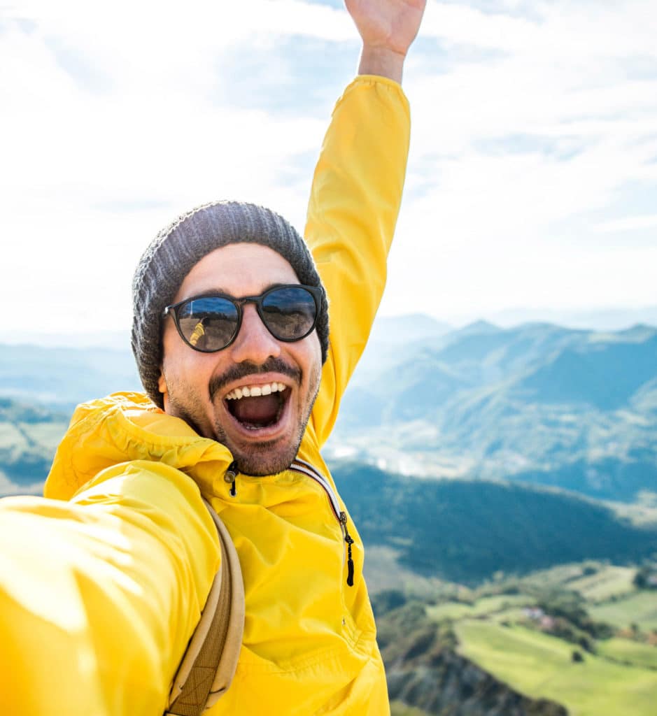Hiker man taking selfie portrait on the top of mountain